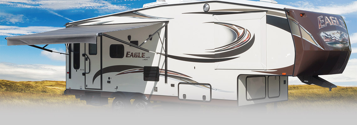 A white Jayco Eagle RV parked in the desert